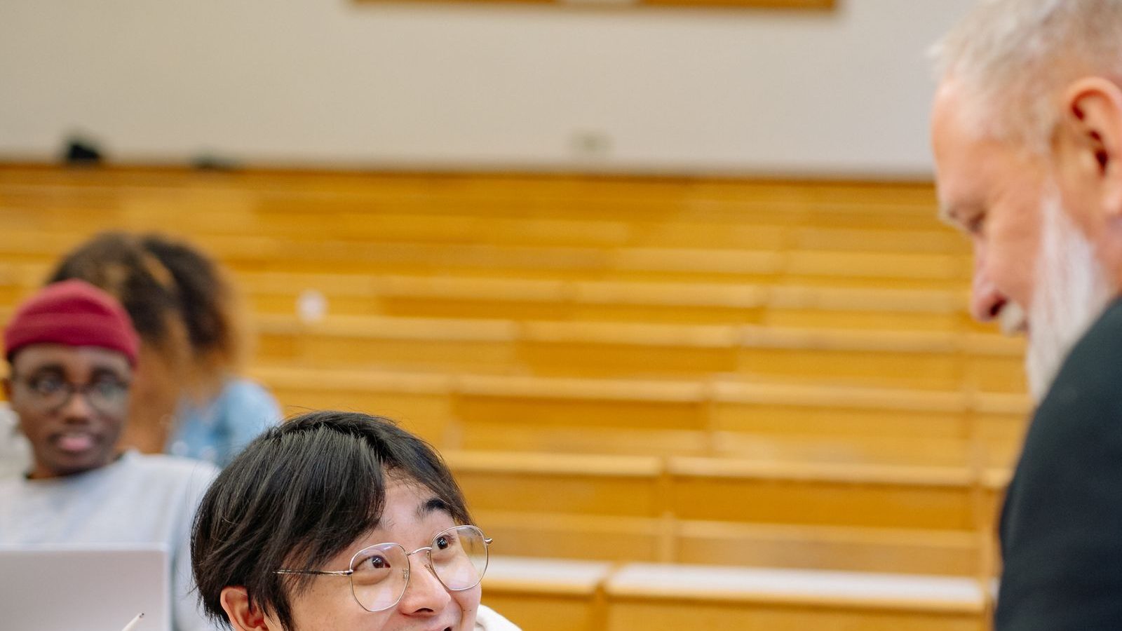 Profesor impartiendo clase a estudiantes en aula universitaria.